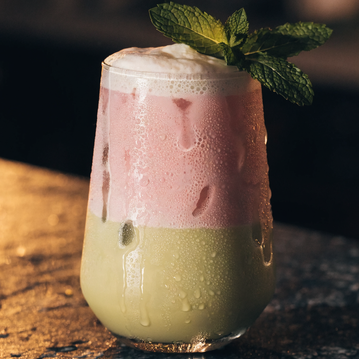 Iced summer drink with pistachio and rose tones on a dark bar | Addtocart Dubai UAE