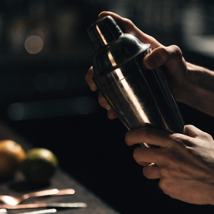 Bartender shaking a cocktail under dramatic competition light | Addtocart Dubai UAE