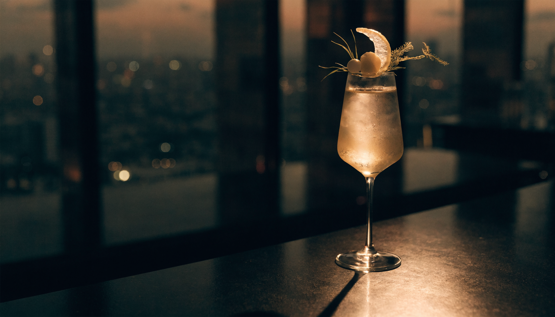 Elegant signature cocktail on a bar high above a city skyline | Addtocart Dubai UAE