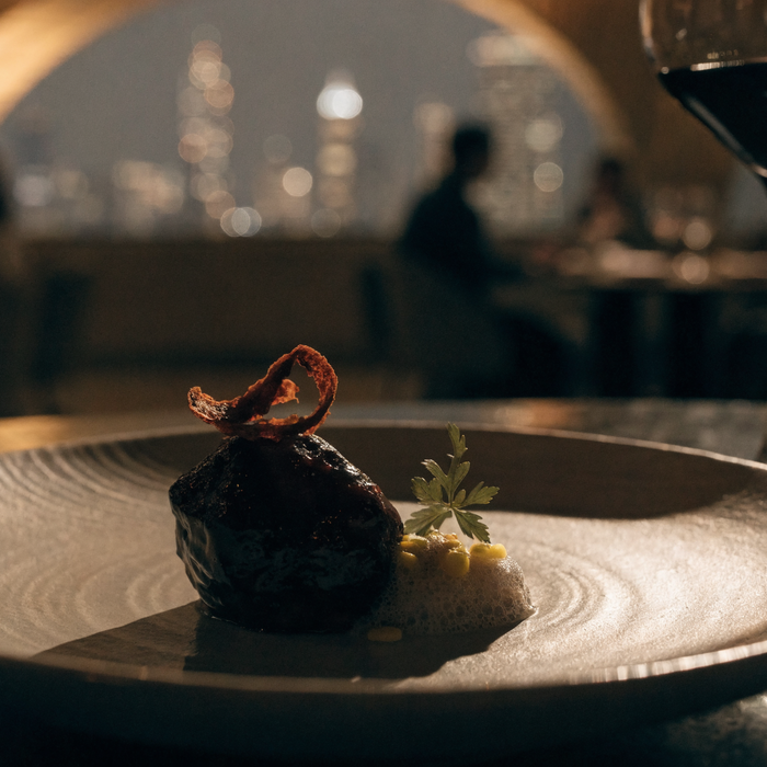 Elegant plated fine-dining dish with a Dubai skyline behind | Addtocart Dubai UAE