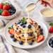 Condensed milk drizzled over berry pancakes